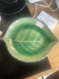 Green leaf-shaped ceramic dish with molded vein texture and scalloped edge