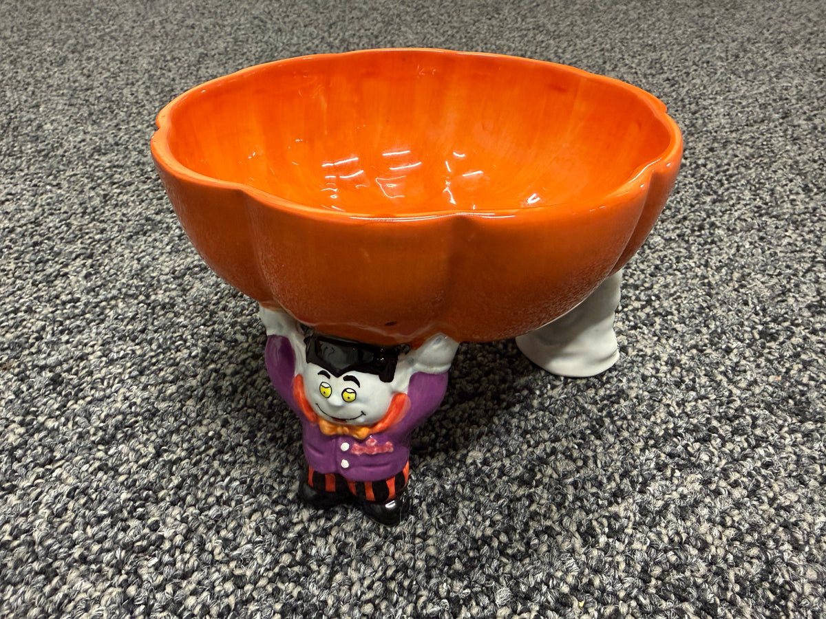 Ceramic Halloween Dracula figurine holding orange pumpkin candy bowl