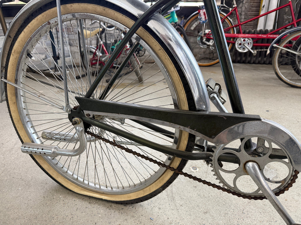 Rear wheel and drivetrain detail of vintage Schwinn tank cruiser, chrome fender and coaster brake
