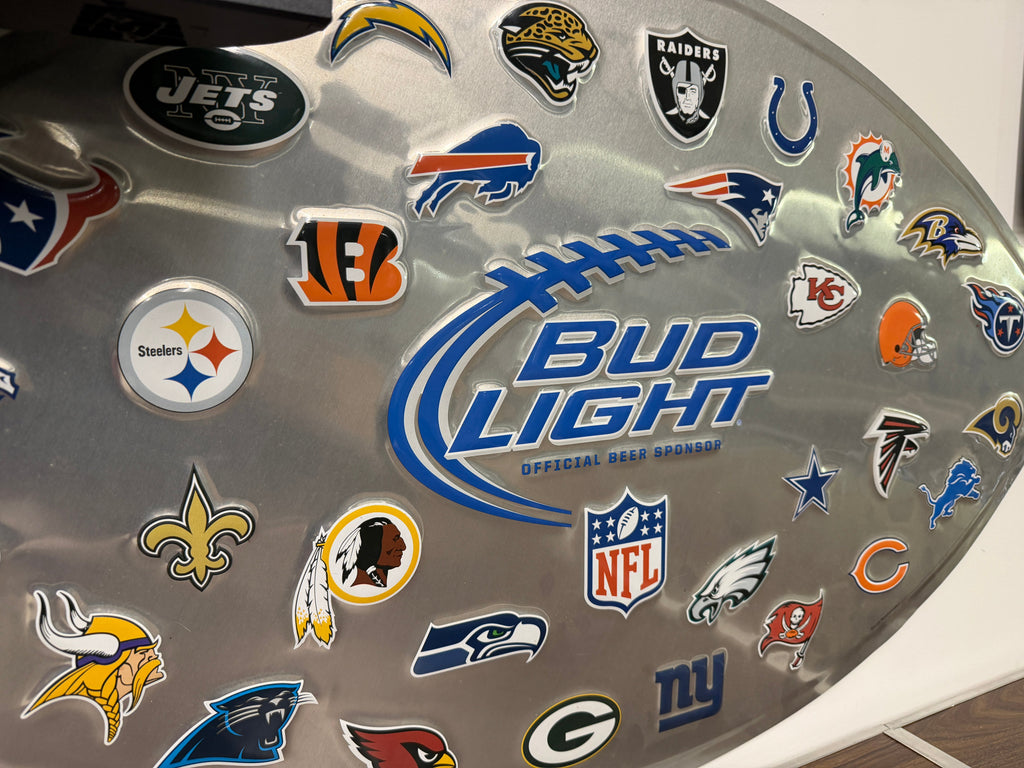 Close-up of Bud Light NFL Official Beer Sponsor football wall sign showing team logos including Steelers, Saints, Vikings, Bills, Raiders, Chiefs, Cowboys, Eagles, Seahawks, and more with Bud Light Official Beer Sponsor branding