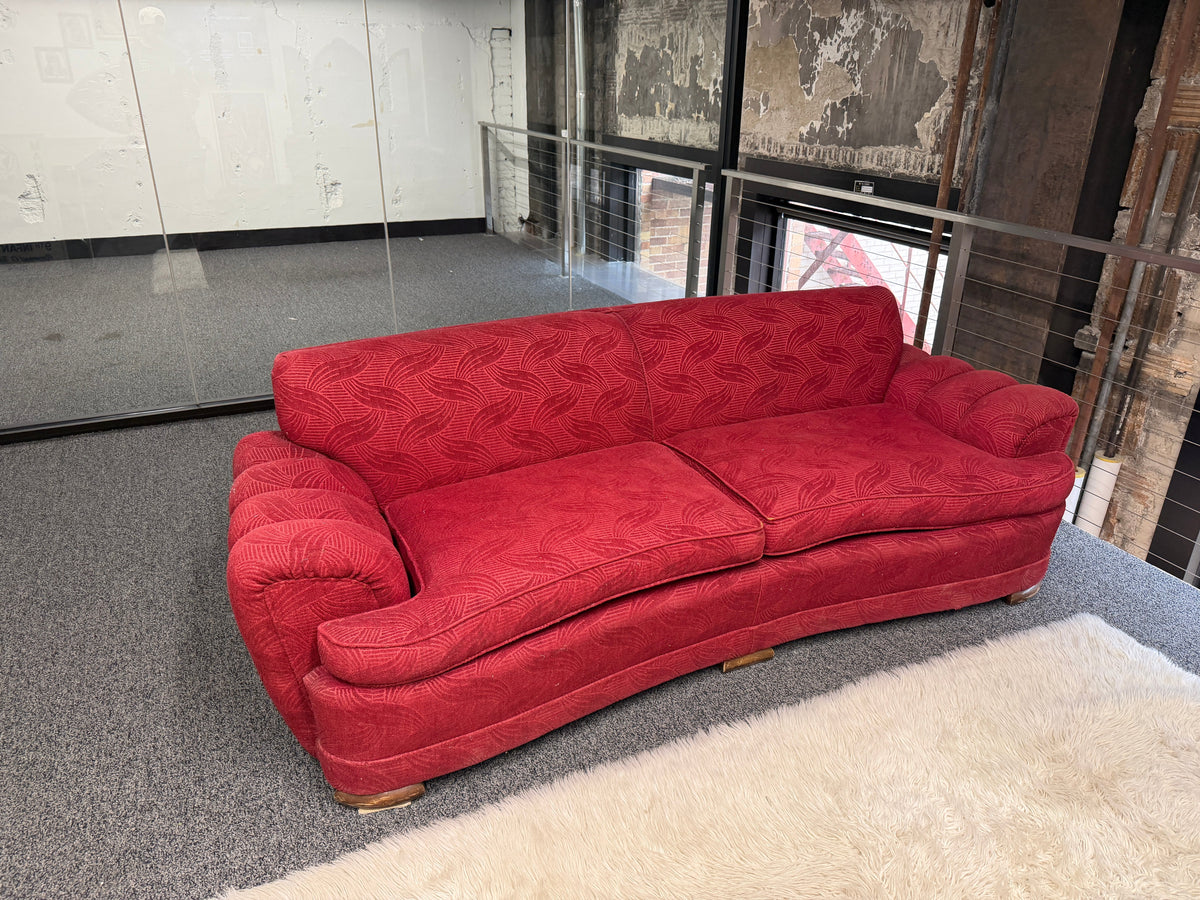 Red patterned rolled arm sofa with deep red woven upholstery, oversized seat cushions, curved profile, and decorative wood feet — statement furniture on consignment at The Foundry by History Loves Company in downtown Pontiac, Michigan