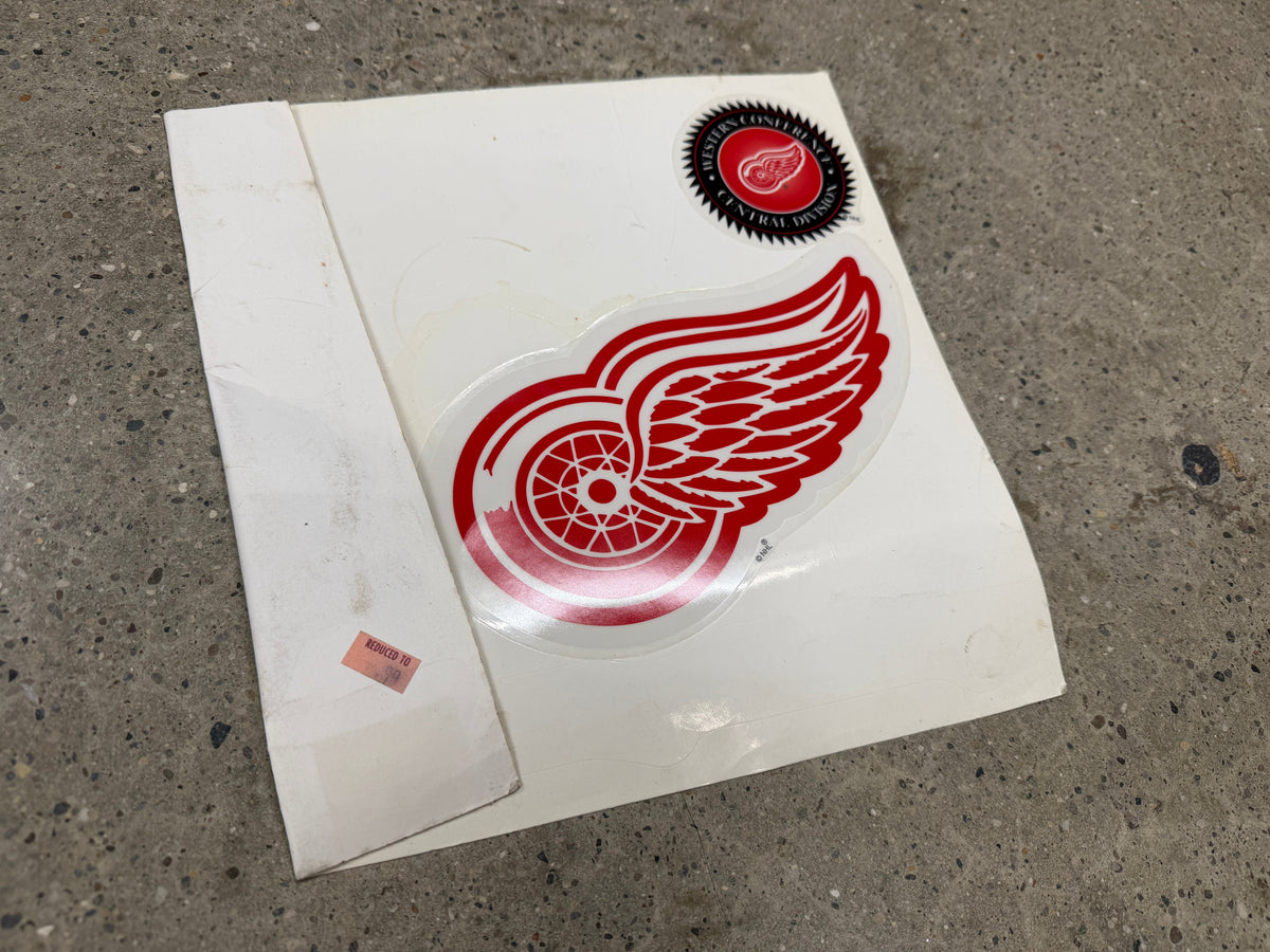 Detroit Red Wings winged wheel die-cut decal on original white backing, Western Conference Central Division seal, never applied