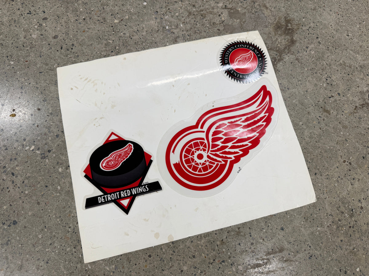 Detroit Red Wings 3-piece vintage decal set on original backing — winged wheel die-cut, hockey puck diamond logo, Western Conference Central Division seal