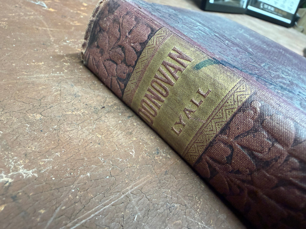 Spine of Donovan by Edna Lyall showing gilt lettering DONOVAN LYALL on embossed purple-brown cloth, c.1895 Lotus Series