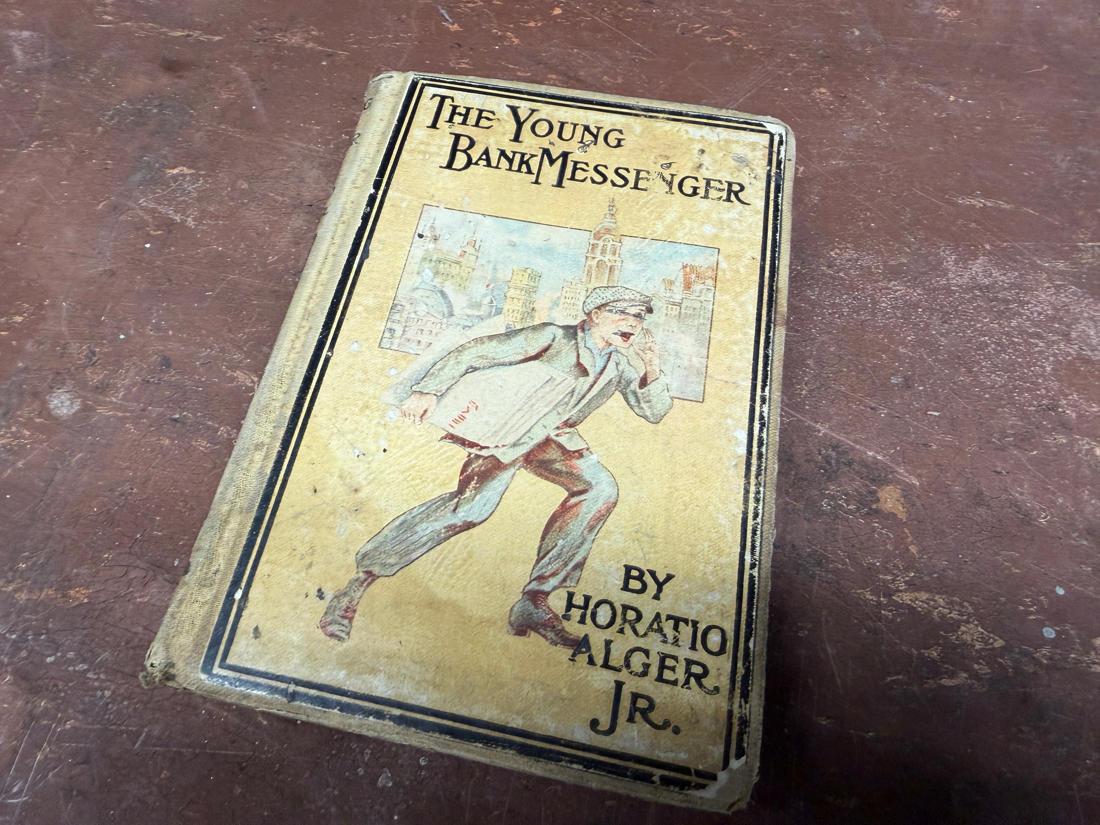 The Young Bank Messenger by Horatio Alger Jr., 1898 first edition, full-color cover illustration of boy running with envelope through city street