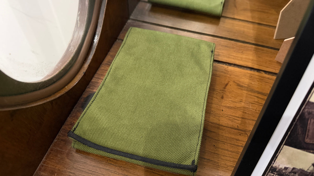 The Forge Hip Pack in olive green woven canvas, Pontiac Built by The Foundry, on wooden surface