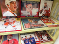 Detroit Free Press Red Wings collector prints on shelf including The Dominator Hasek, Yzerman, Lidstrom, Shanahan, Precious Medals and more