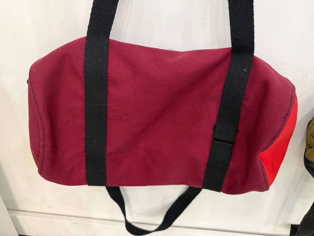 The Day Trip Duffle in maroon with red end panels and black straps, Pontiac Built by The Foundry