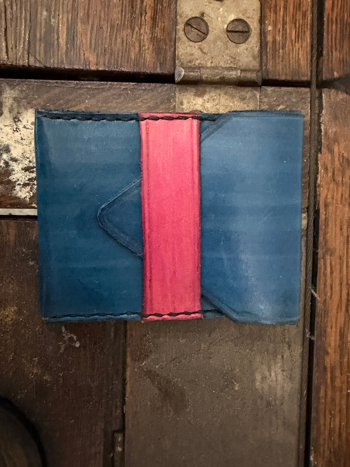 The Courier Envelope Wallet in cobalt blue leather with hot pink center spine and angled card pockets, hand-stitched, Pontiac Built