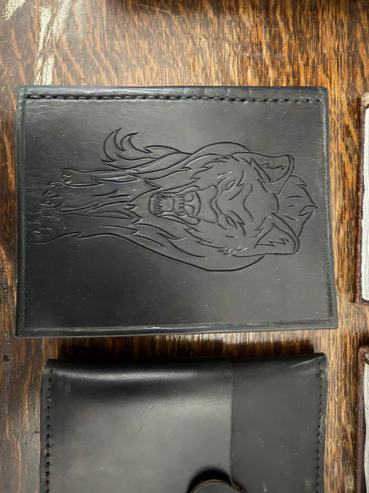 Handmade leather journal with deep-carved running wolf tooled design on jet black leather cover, no paint, recycled card paper pages