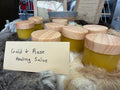 Gold & Rose Healing Salve by Everly Rose in frosted glass jars with natural wood lids displayed on fur, handcrafted botanical salve