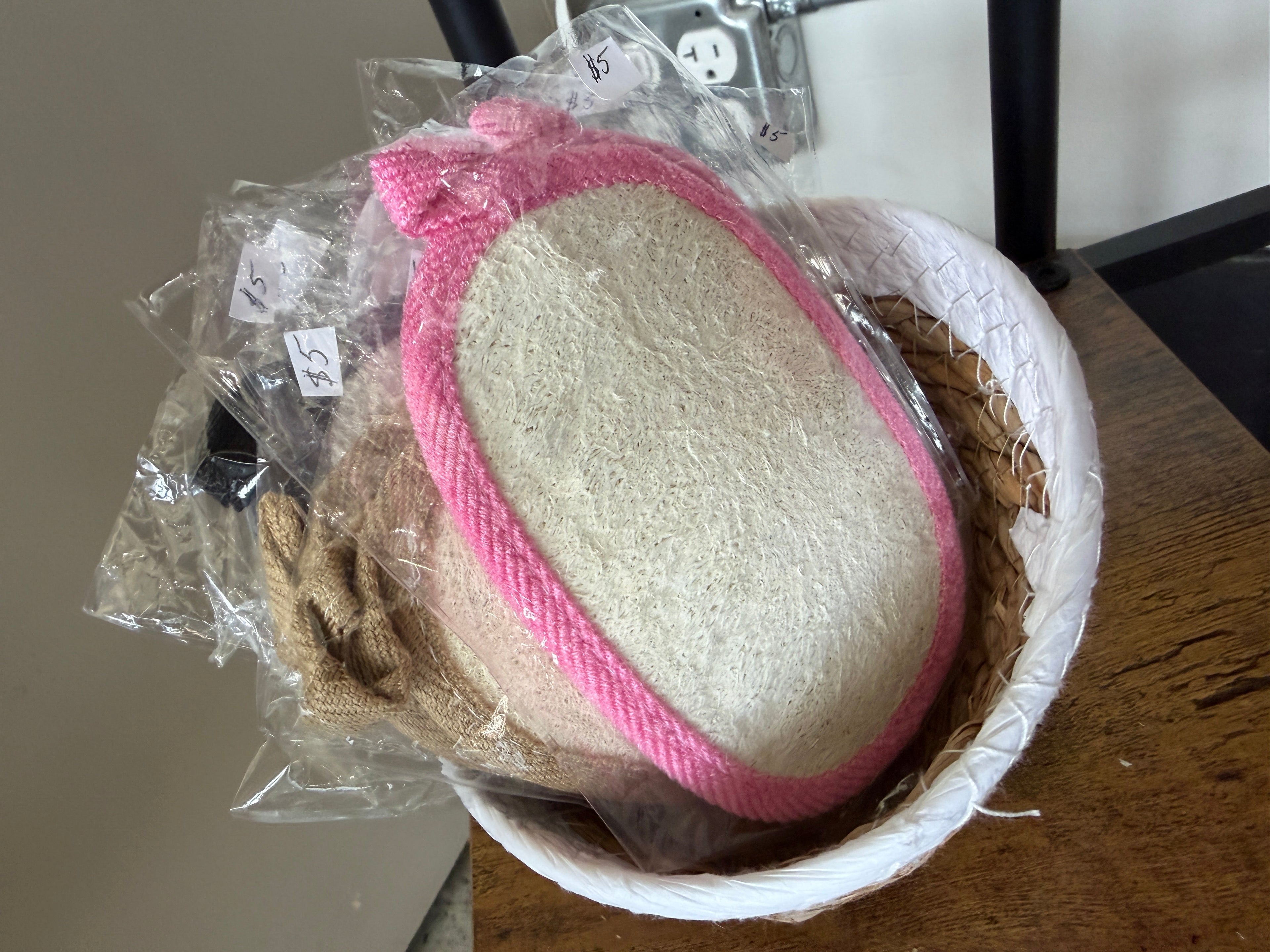 Natural loofah back scrubbers with pink trim cord by Vallee Naturals individually wrapped in basket