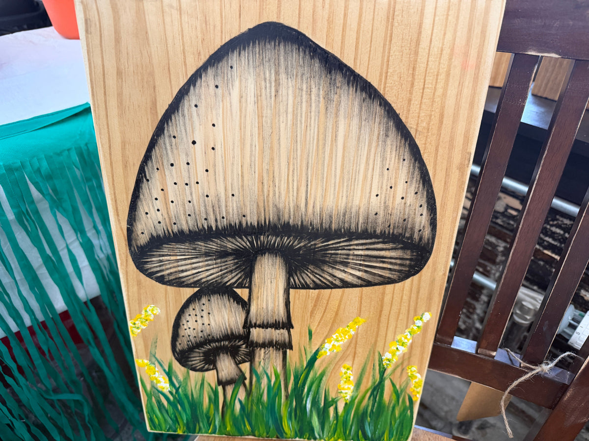 Hand-drawn mushroom scene on wood panel with grass and yellow wildflowers by Renee Reese