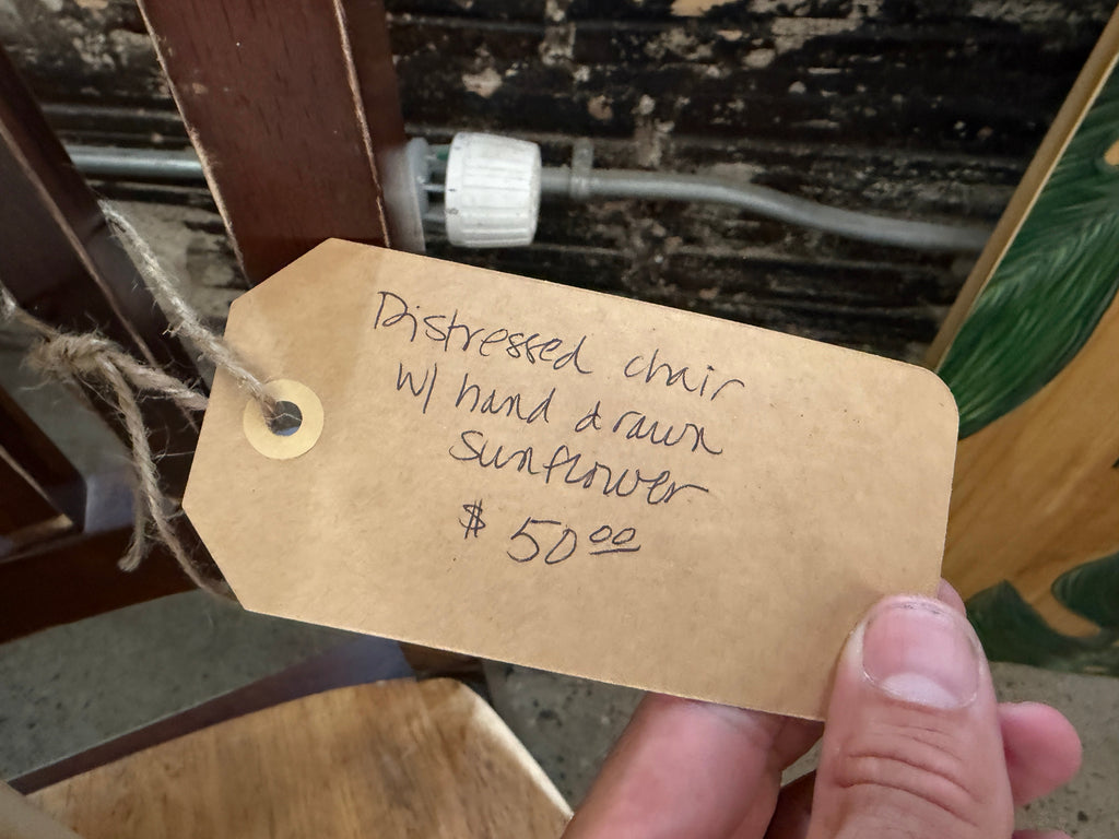 Price tag reading distressed chair with hand drawn sunflower $50