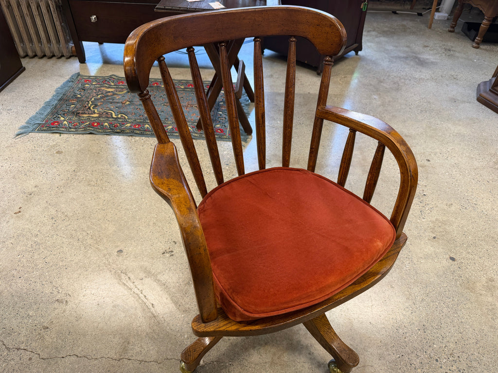 Antique oak banker swivel chair with rust upholstered seat, angled view