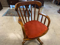 Antique oak banker swivel chair with rust upholstered seat, angled view