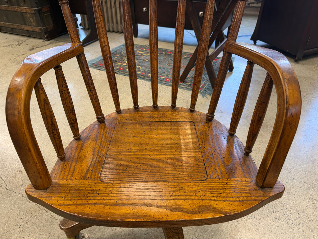 Antique oak banker swivel chair seat detail showing wood grain and spindle back