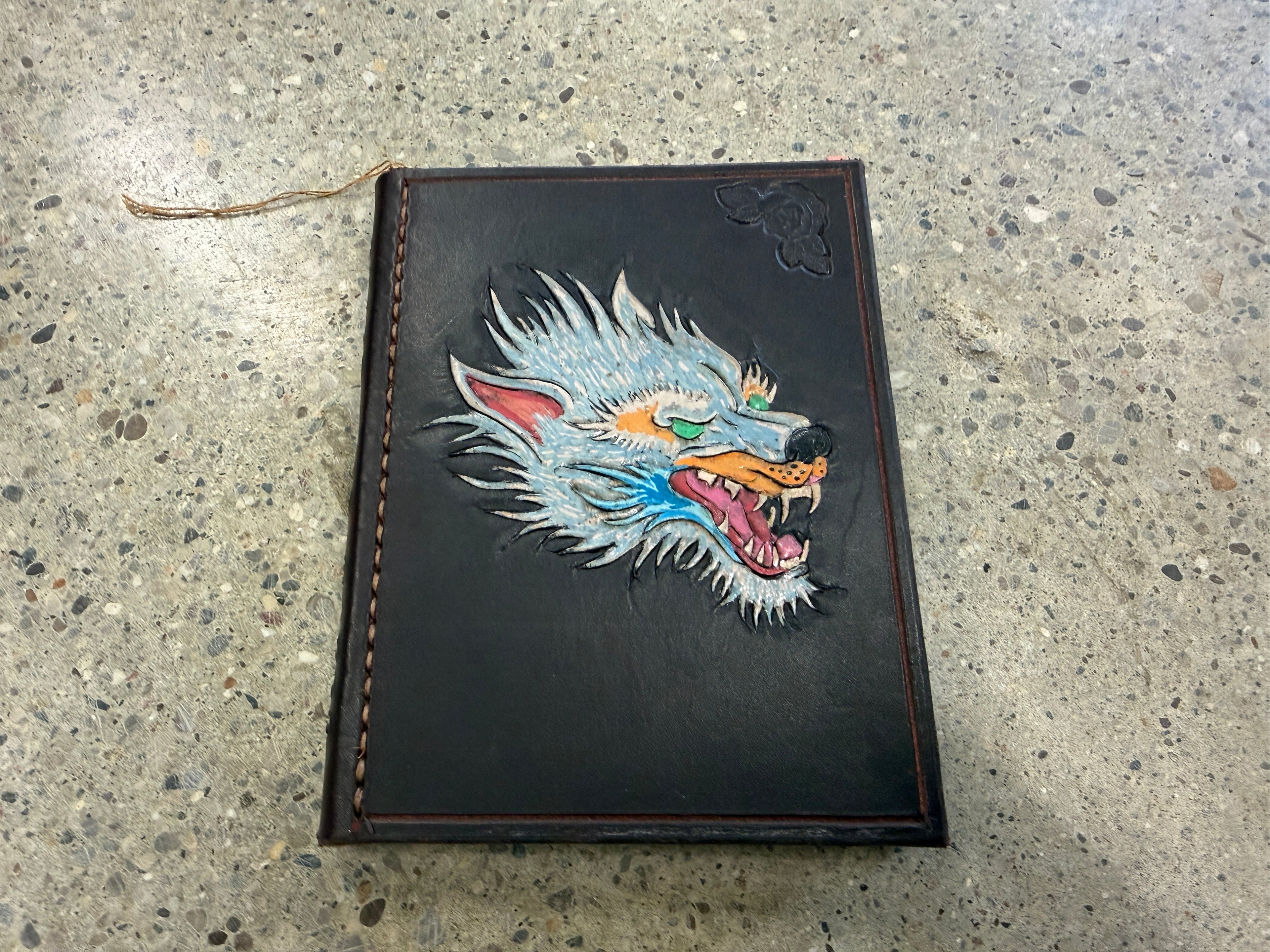 Hand-tooled black leather journal with snarling wolf head design