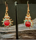Handmade copper burst earrings by Sweet Sinister — red coral center with copper wire sunburst frame