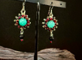 Handmade silver burst earrings by Sweet Sinister — turquoise center stone with silver wire burst and red accent beads