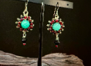 Handmade silver burst earrings by Sweet Sinister — turquoise center stone with silver wire burst and red accent beads