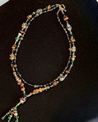 Handmade green multicolor crystal tassel necklace by Sweet Sinister — double-strand black and multicolor crystal beads with tassel drop